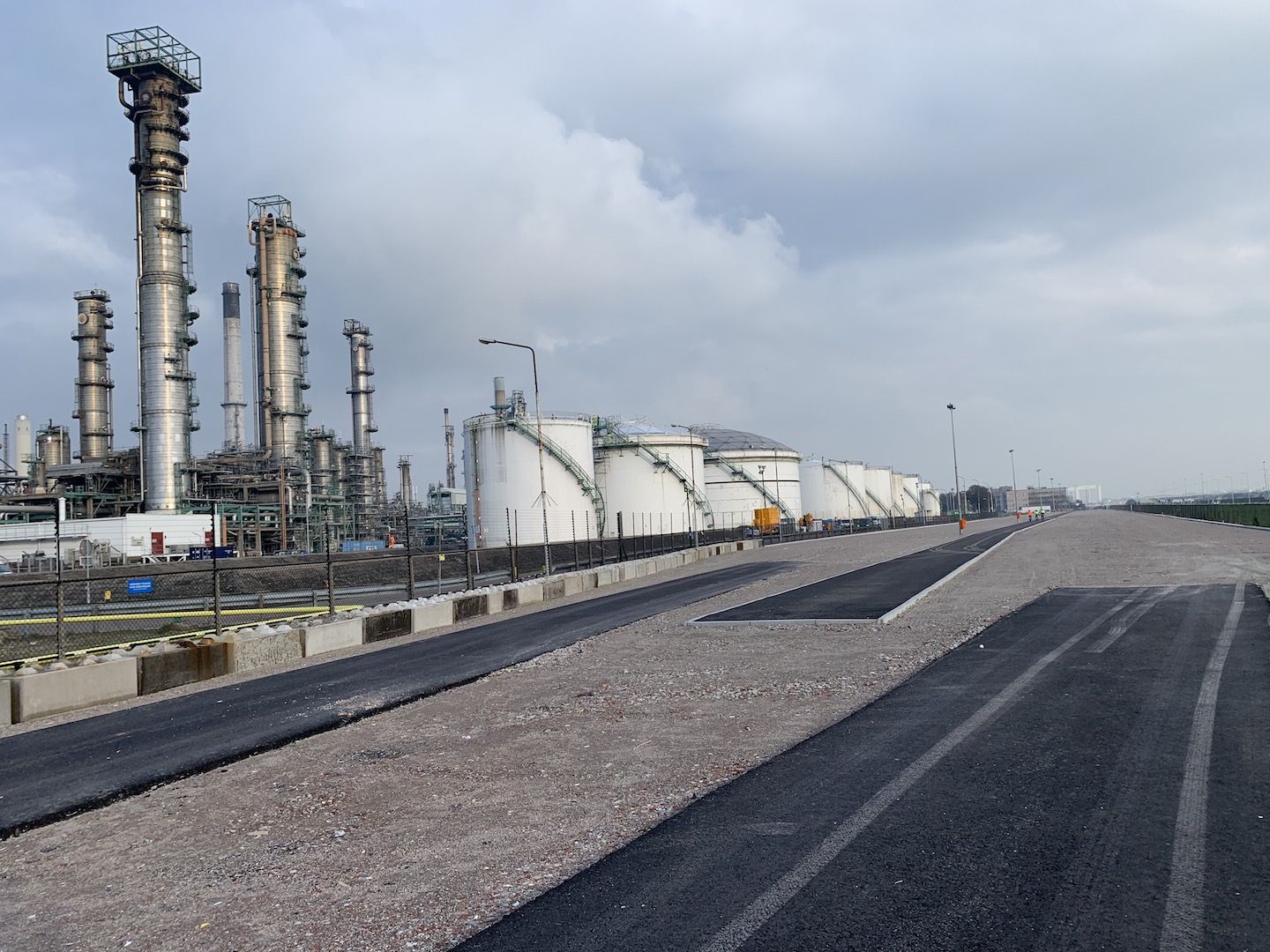 Twee wegen en het voetpad naast de industrie in de Botlek